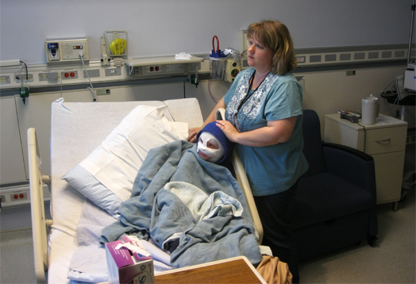 a woman in blue shirt on a hospital bed
