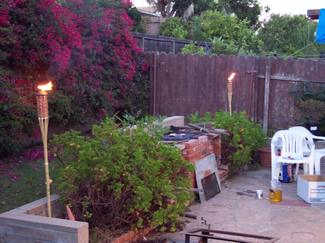 an outdoor fire pit surrounded by greenery and trees