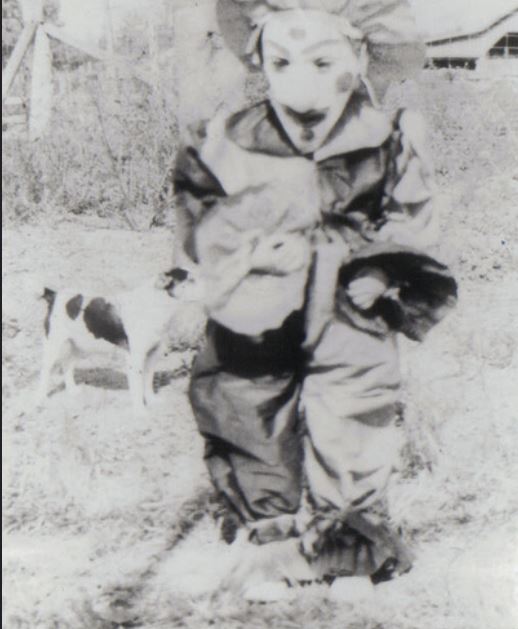 a boy is in front of a dog in the yard