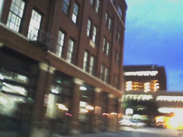 a blurry image of the side of a building and cars