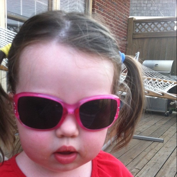  wearing sunglasses on a deck near other objects