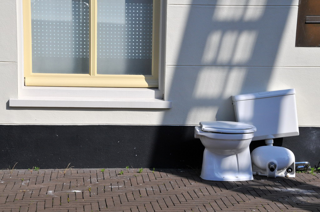 a couple of toilets are next to a window