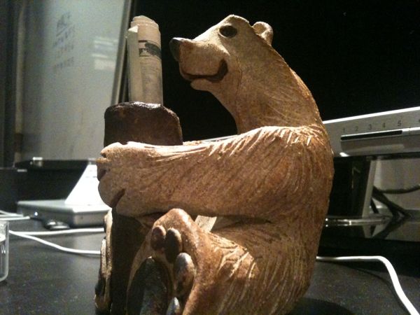 a sculpture of a bear next to a computer monitor