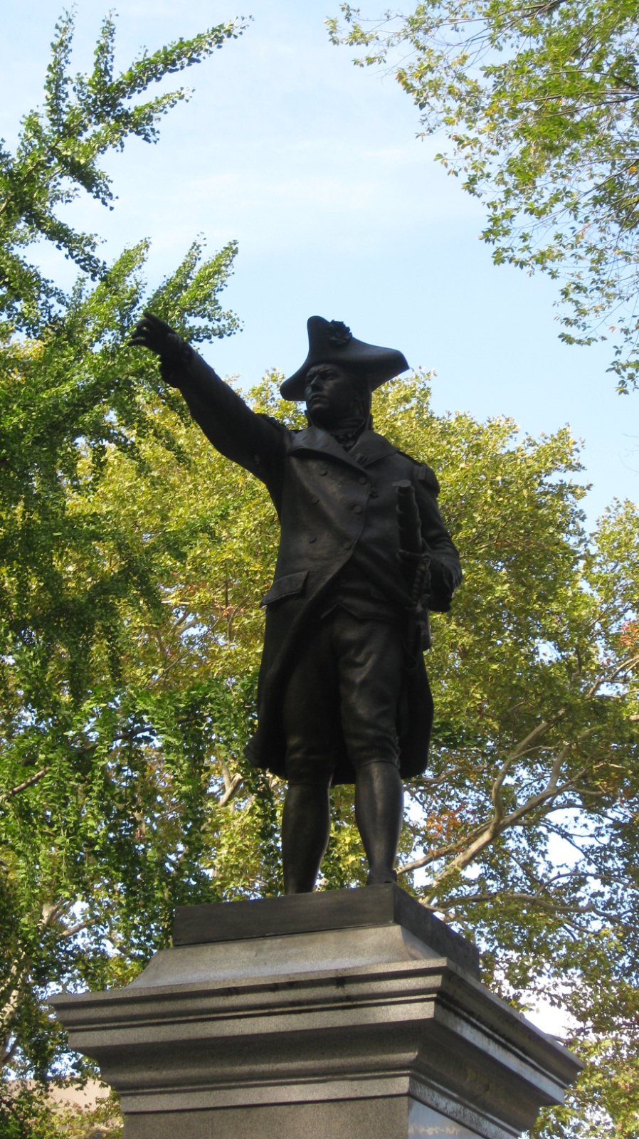 a statue sitting on top of a large stone pedestal