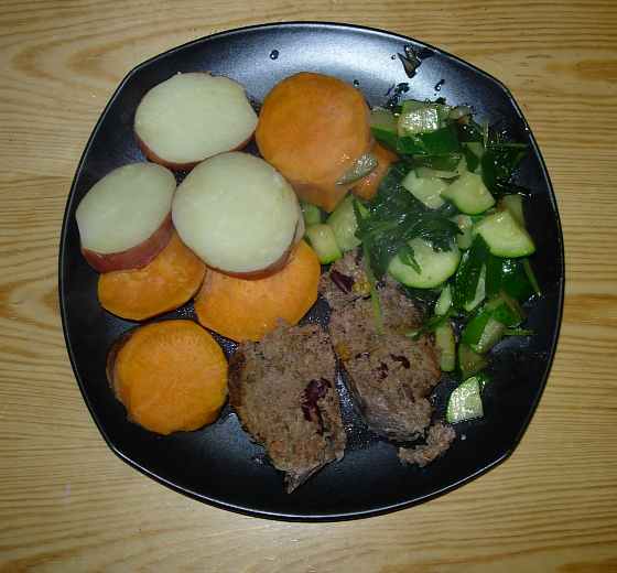 a plate with meat, vegetables, and a slice of orange