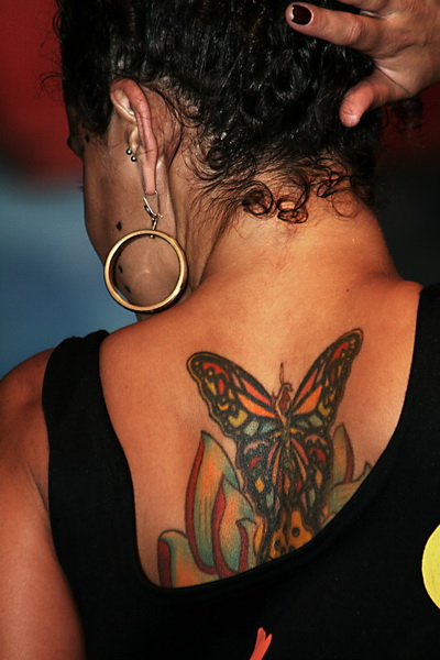 a woman wearing a erfly tattoo on her back