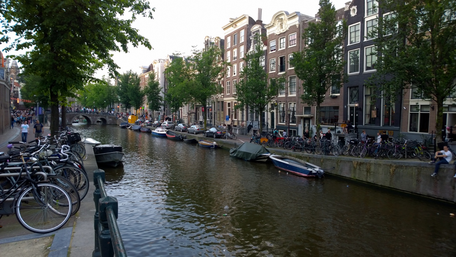 a river running between several houses with bikes parked along each side