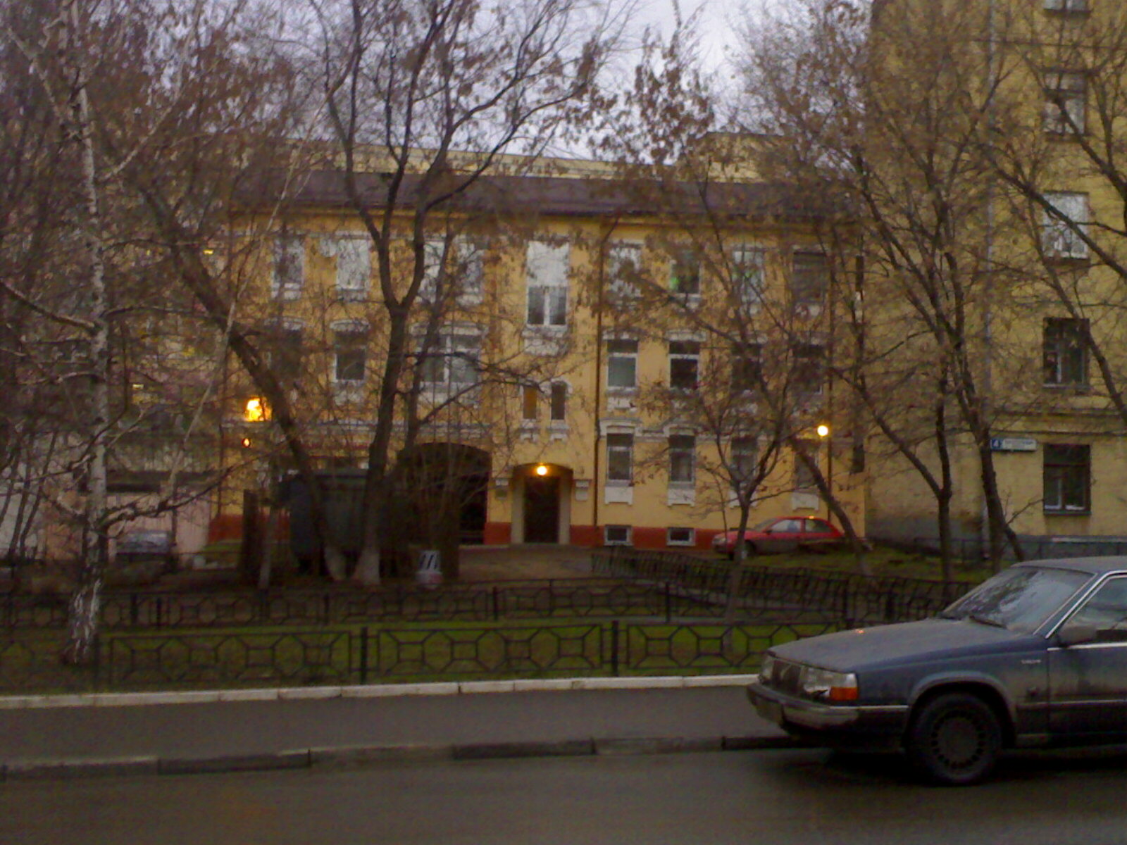 the car is driving down the street next to an old building