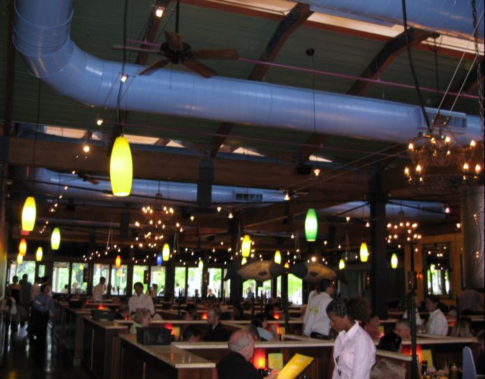 a restaurant has several workers and several yellow lanterns