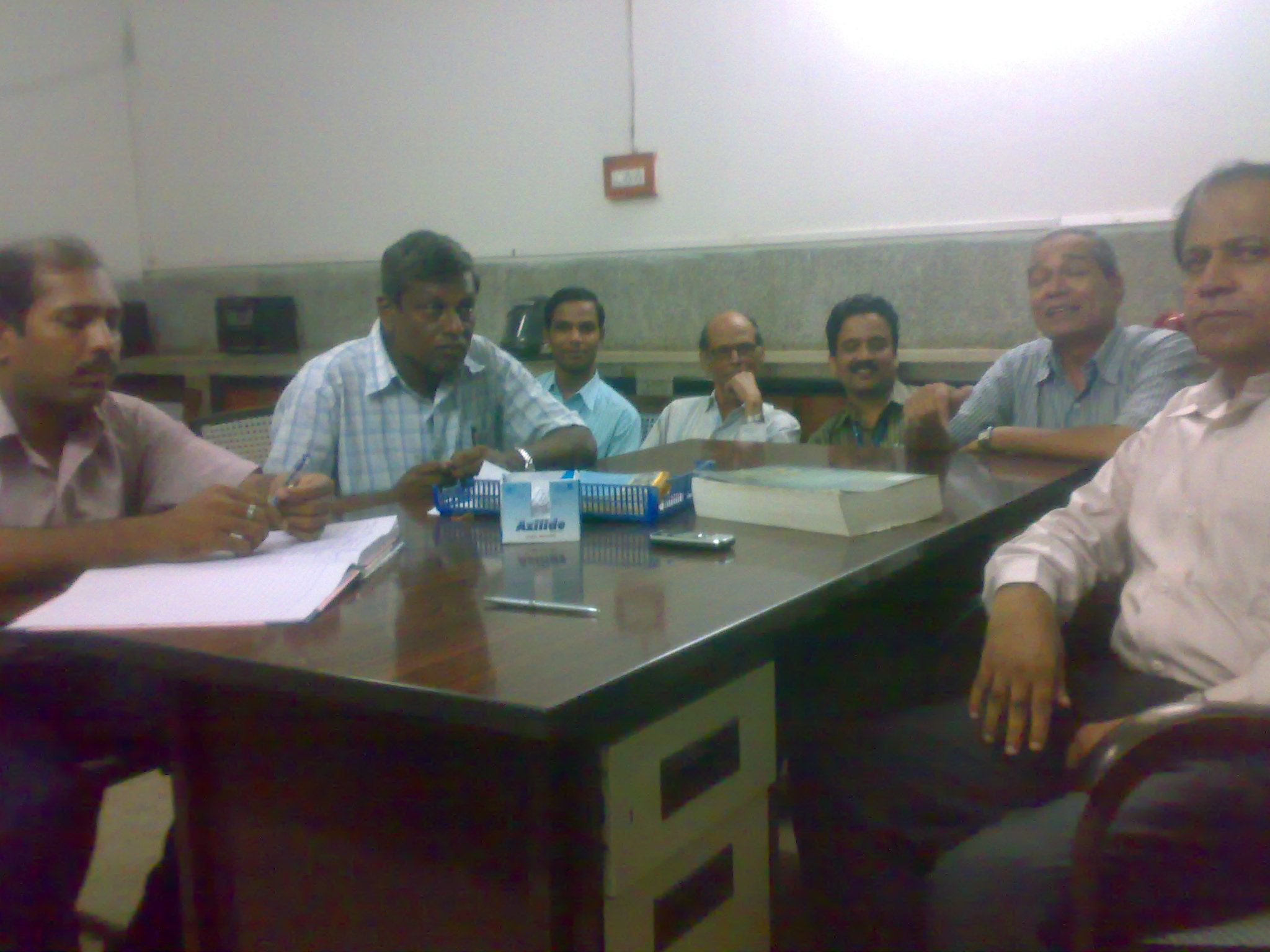 six men sitting around a conference table