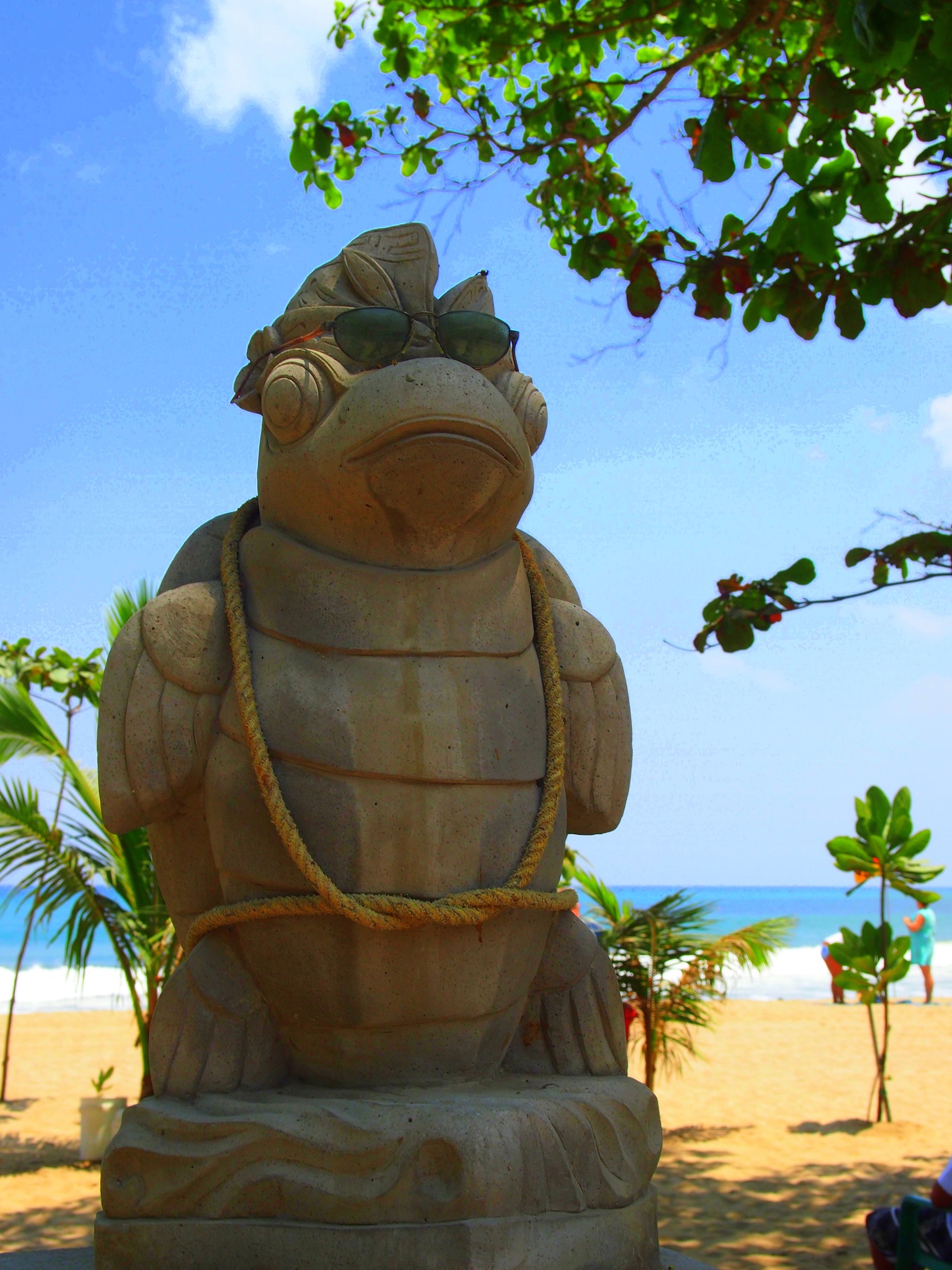 a turtle statue sitting on top of a sandy beach