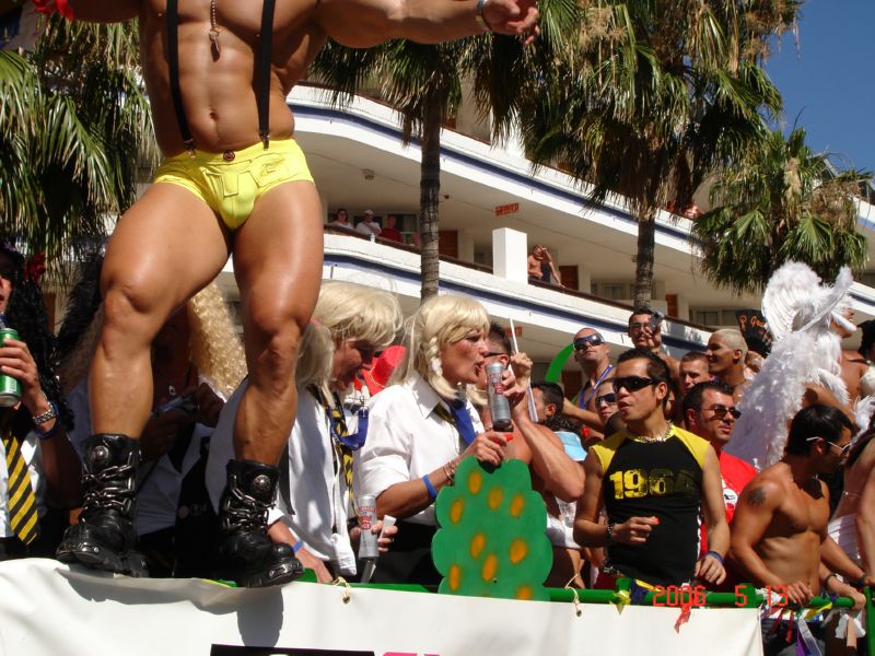 a group of people watching a man in a thong and underwear performing an acrobatic trick