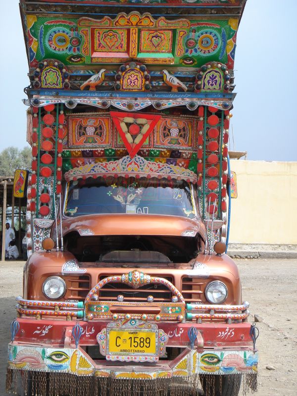 an old rusty pickup truck parked on a dirt road