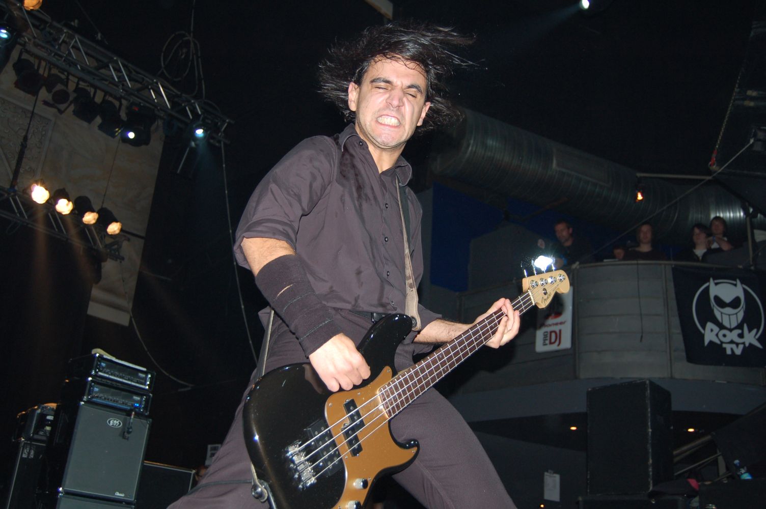 a man in an all black outfit plays a bass guitar