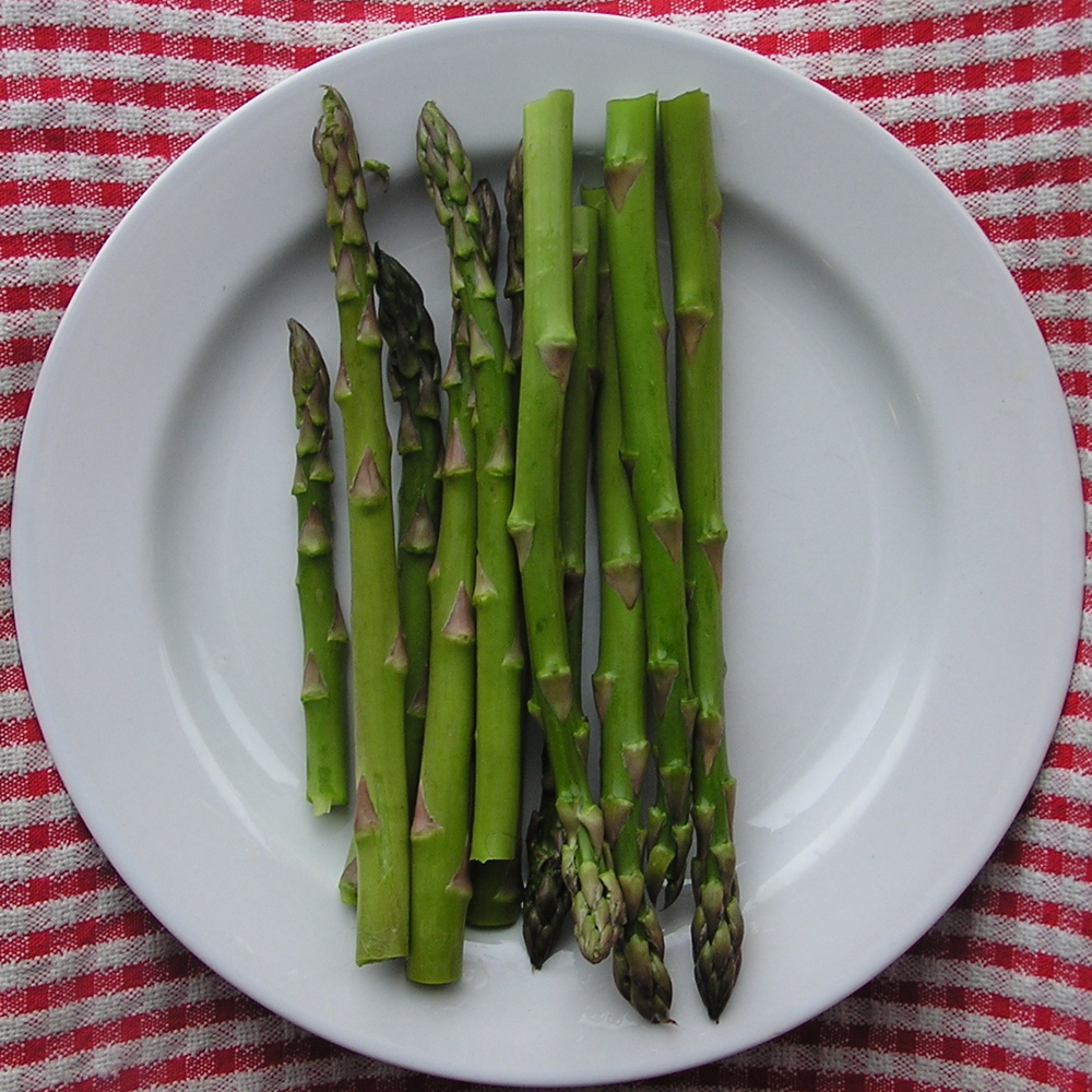 there are several asparagus on a white plate