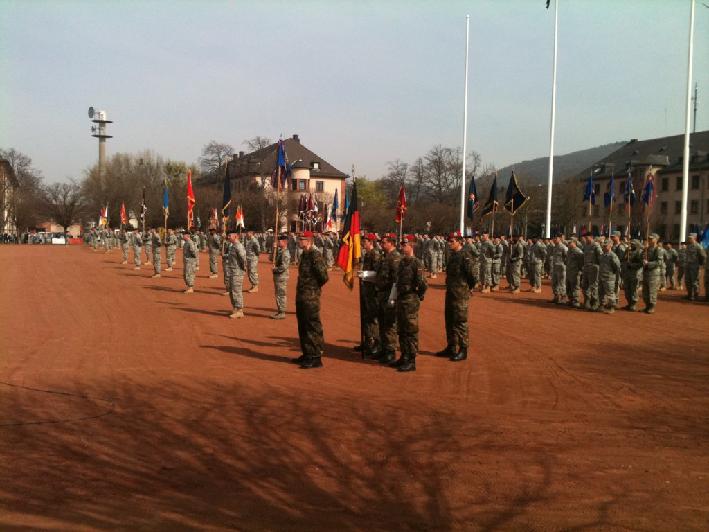 an army parade with people in uniform in front of a building