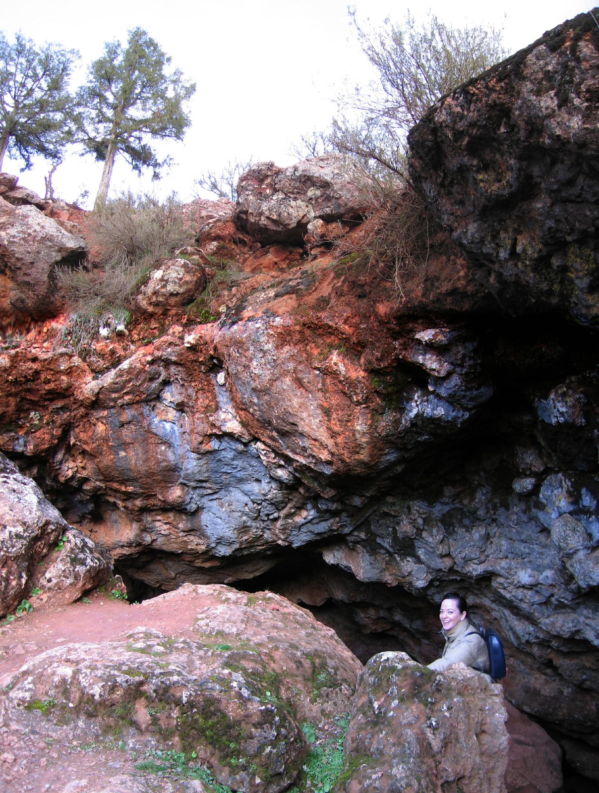 a man standing in a large open cave with another man looking over his shoulder