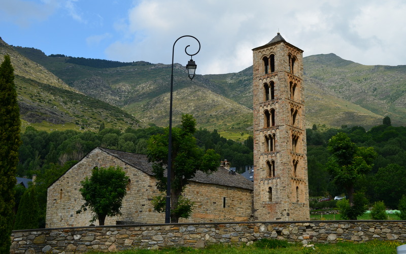 a large stone tower next to trees and mountains