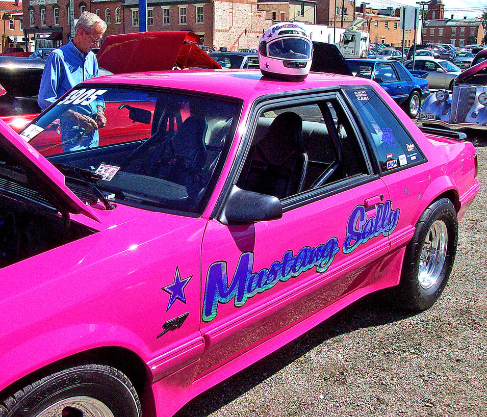 a pink car parked in a parking lot