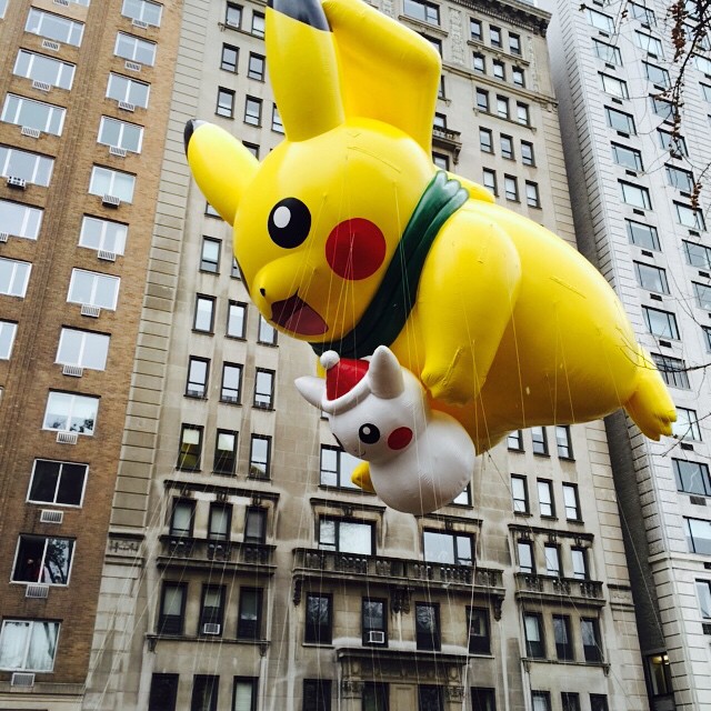 a pokemon balloon flying through the air in front of a large building