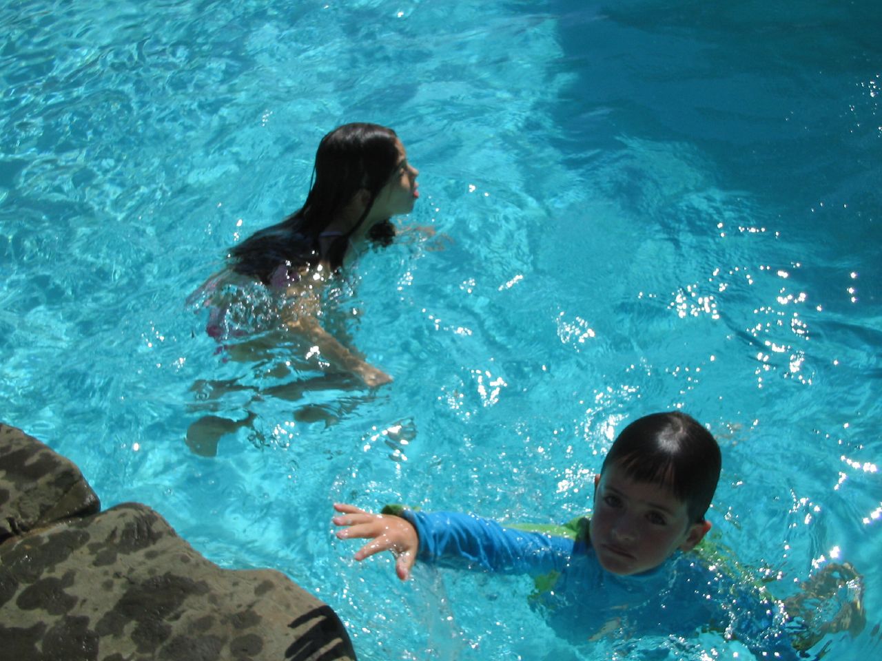 two children in a pool with blue water