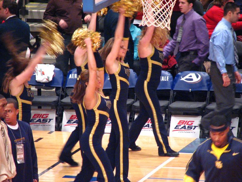 the cheerleaders are holding a basket over their head