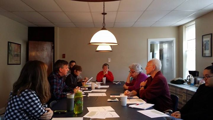 a group of people sitting around a long table