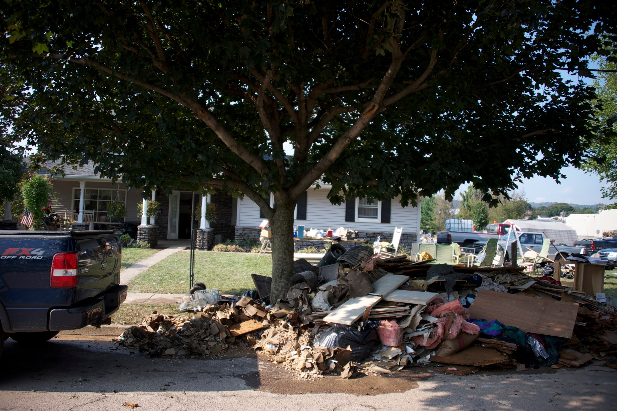 there is a garbage truck parked next to a pile of trash