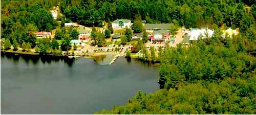 a water front with green trees surrounding the buildings