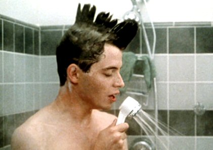 a man brushing his hair in front of a shower