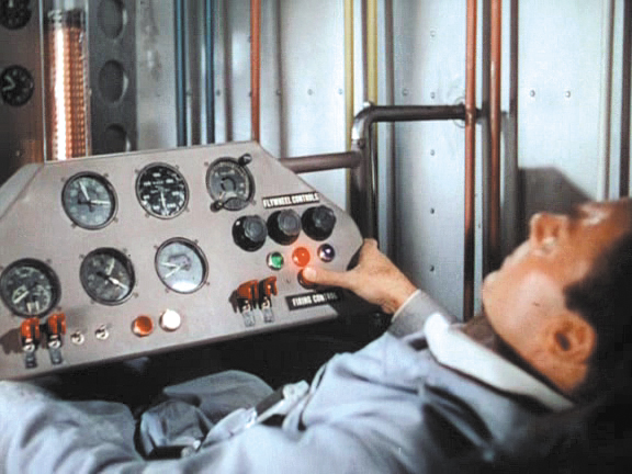a person is setting in front of an old control panel