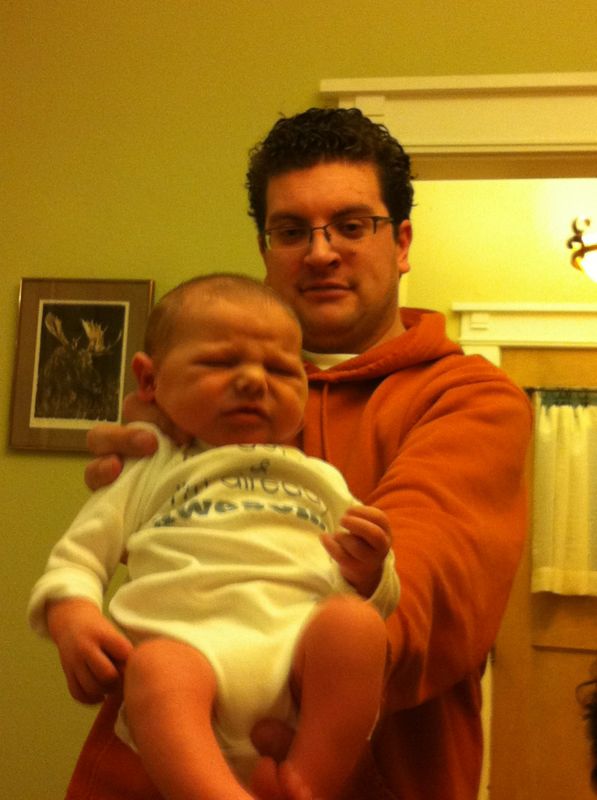 a man is holding a baby in front of his face