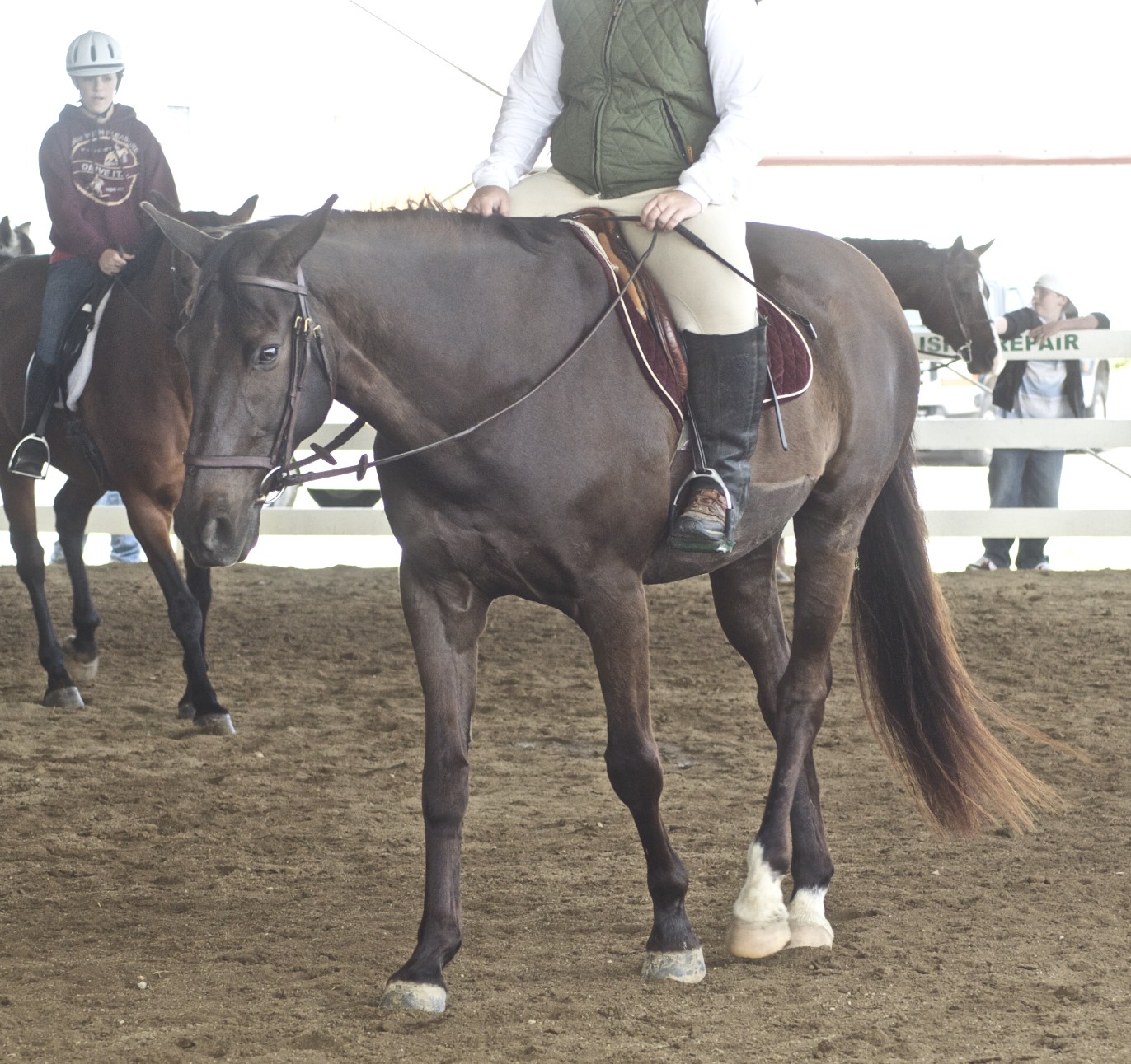 two people are riding horses on the dirt