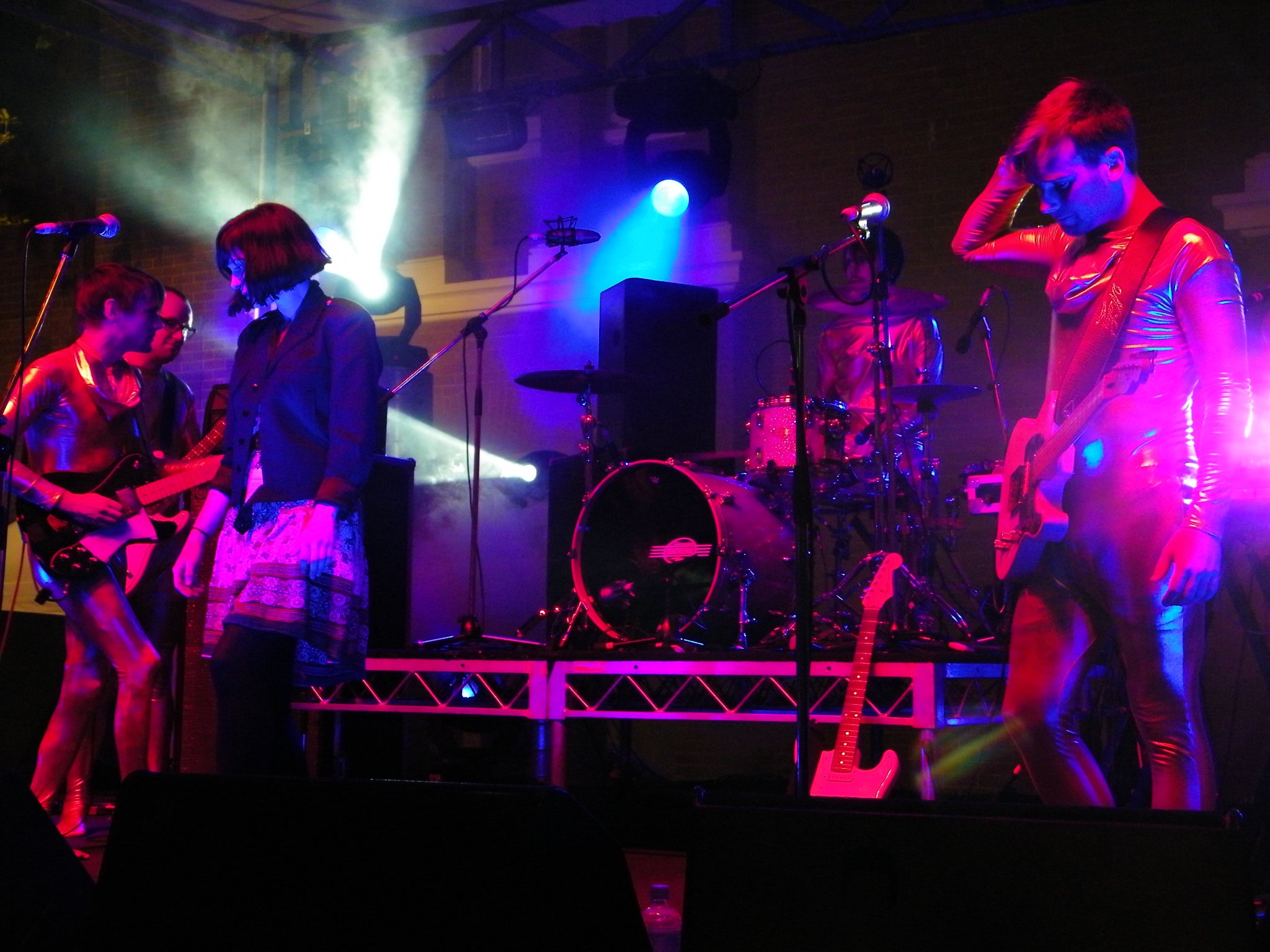 three women singing into microphones at a concert