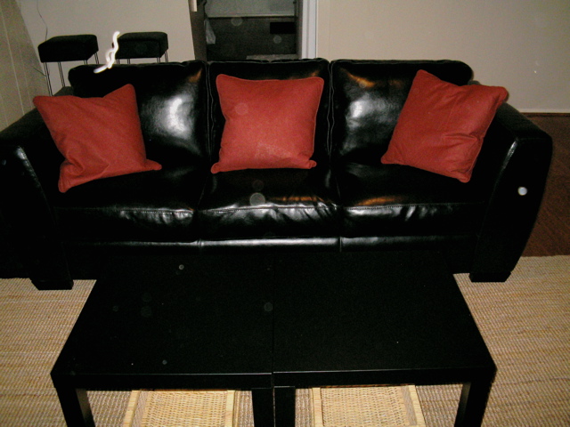 an image of a living room setting with black leather couches