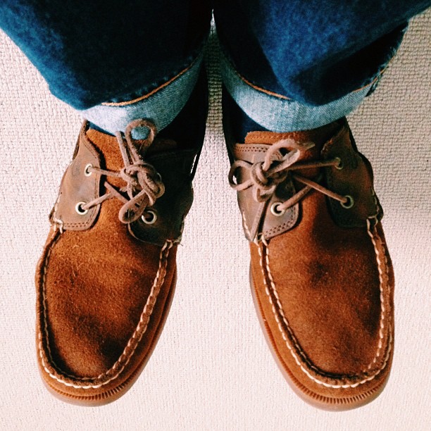 a pair of brown shoes next to a person's feet