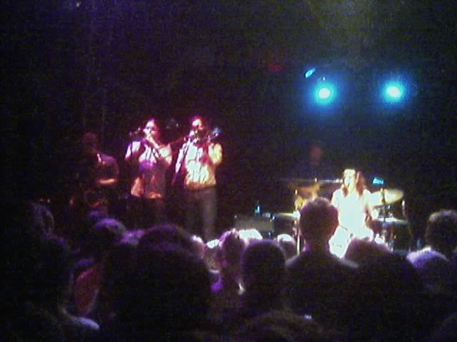 three people are on stage at a concert