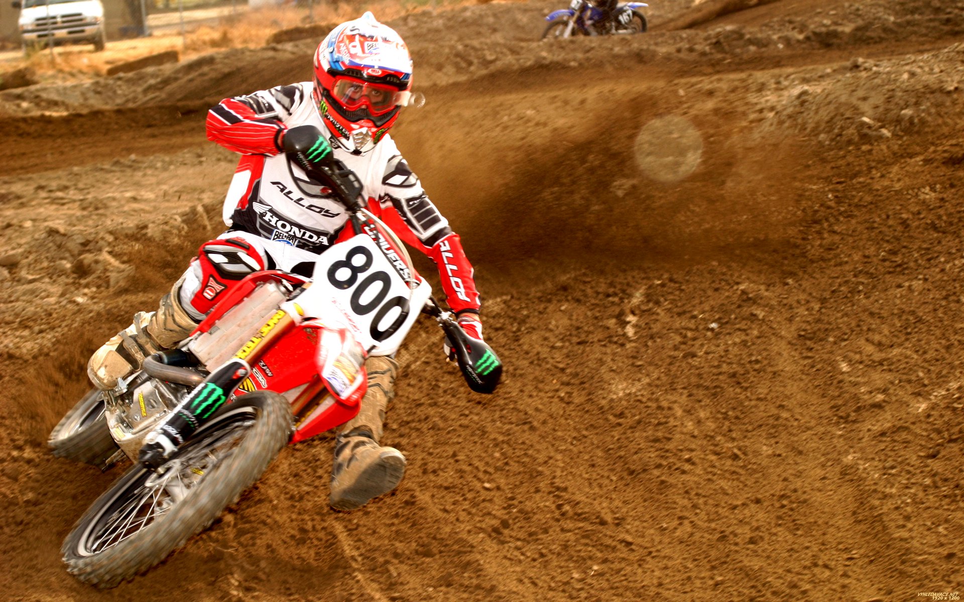a motorcross racer in red gear going around a curve