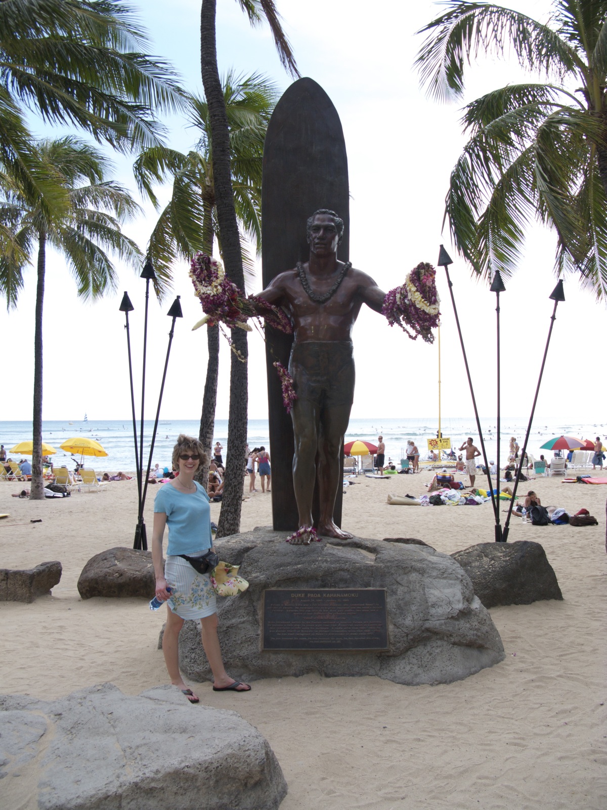 a person standing near a statue on the beach