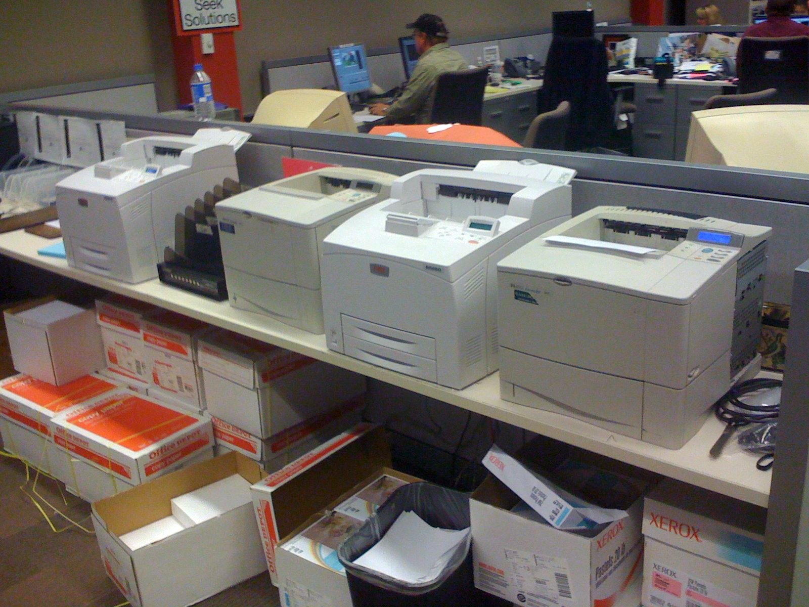 many computers sit on shelves with boxes and office items