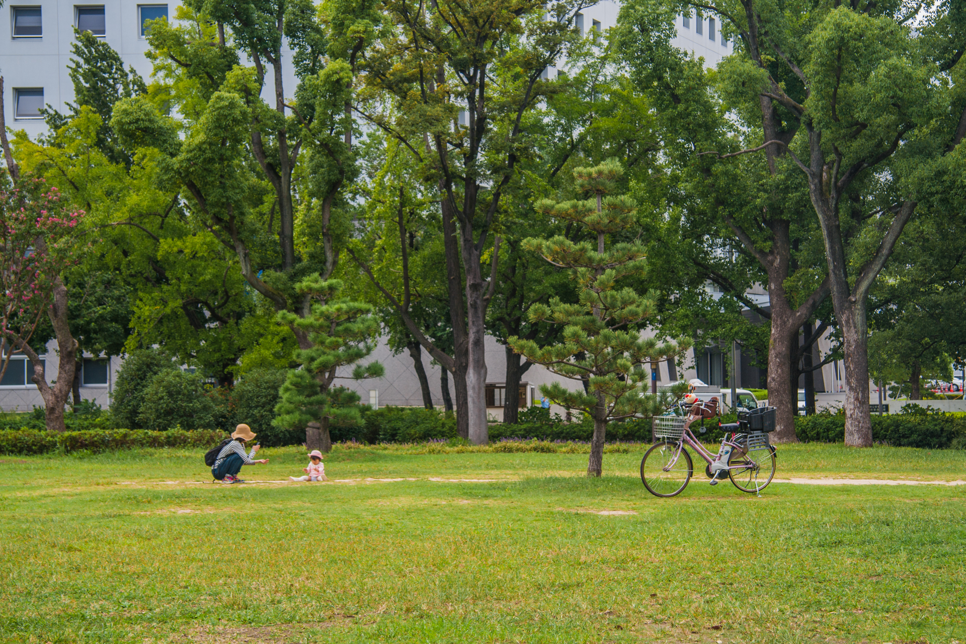 a person that is sitting on the grass with a bike