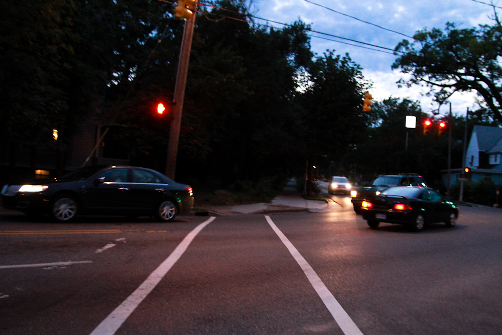 a car waits at an intersection at night