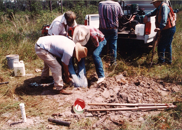 a group of people putting soing on the ground near a truck
