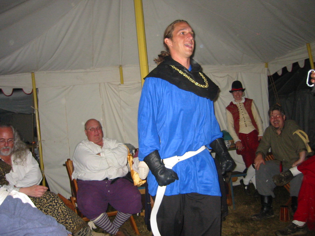 an old man dressed up in his native american costume standing next to other people