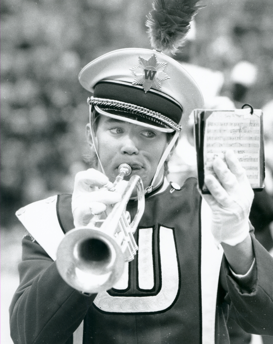 a soldier holding a trumpet and cell phone