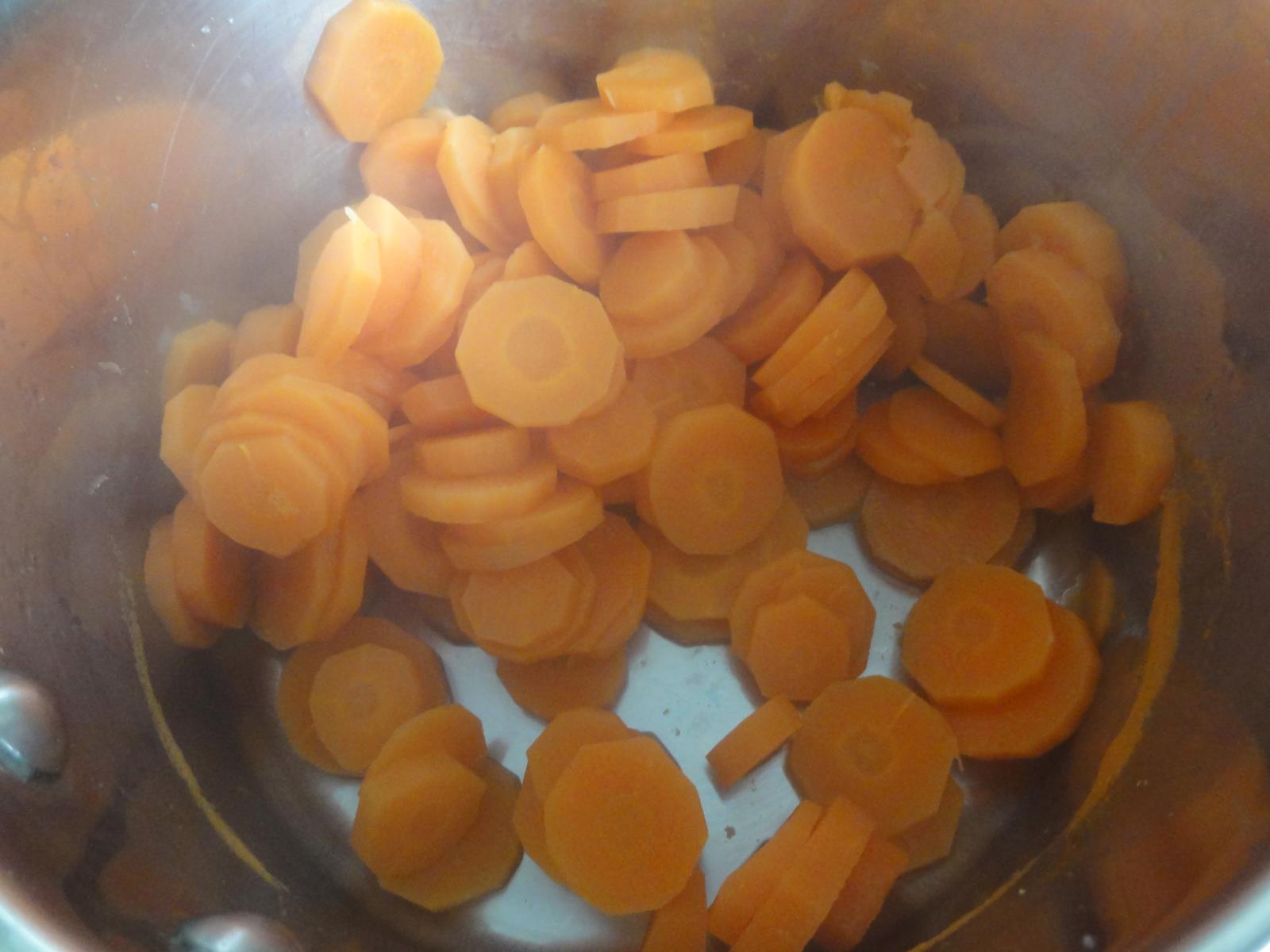 peeled carrots simmering in a large pot