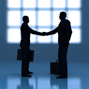 two businessmen shaking hands in front of the wall