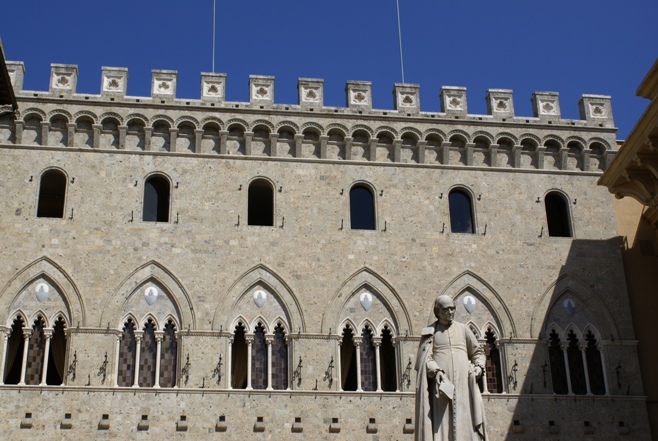 the front facade of a large castle with statues