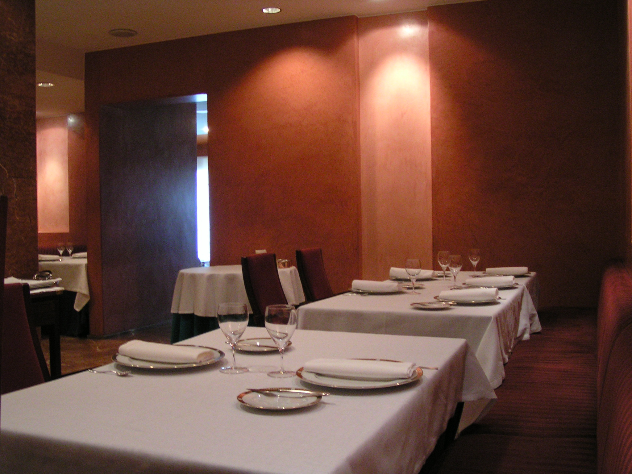 two tables in a room with chairs and plates