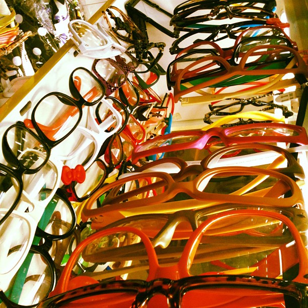 pairs of eyeglasses sitting on display in an open display case